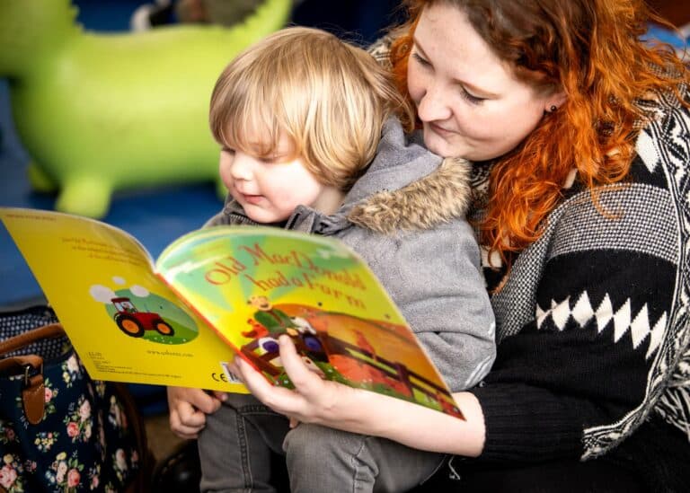 Woman with her child, reading a book